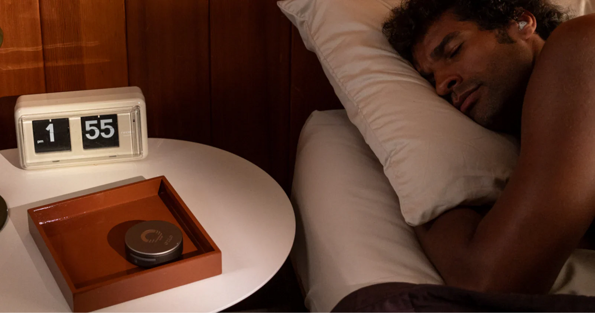 man sleeping with sleepbuds on his left side 